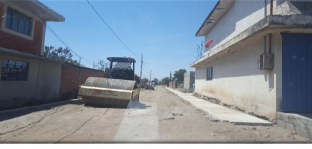 Maquinaria compactando pavimento en calle urbana